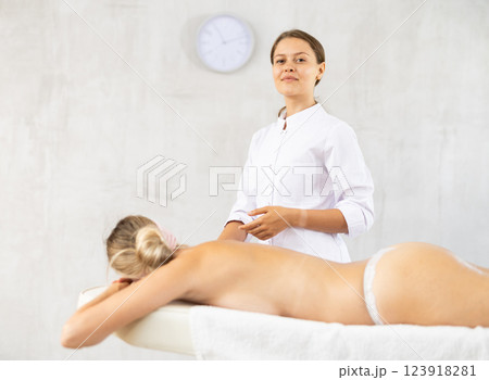 Successful young female massage therapist standing in procedure room Successful young female massage therapist standing in procedure room 123918281