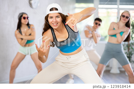 Female teen teacher with young girls in dark glasses and ball cap dance Jazz-modern at lesson Female teen teacher with young girls in dark glasses and ball cap dance Jazz-modern at lesson 123918414