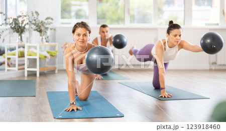 Group of men and women doing pilates with softball Group of men and women doing pilates with softball 123918460