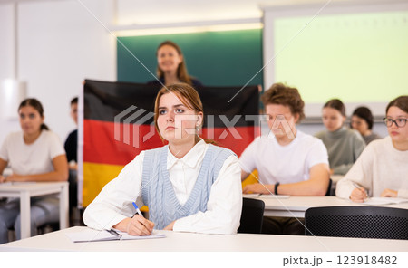 Teacher stands behind students with German flag 123918482