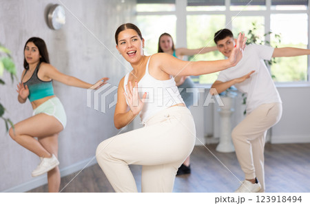 Girl teen perform choreographic exercise and teach energetic waacking dance with friends Girl teen perform choreographic exercise and teach energetic waacking dance with friends 123918494