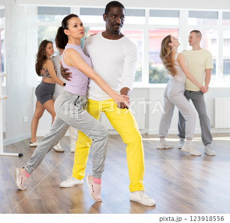 Expressive man and woman rehearsing tango in dance class 123918556