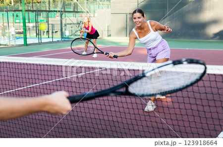 Young woman in shorts playing tennis on court Young woman in shorts playing tennis on court 123918664