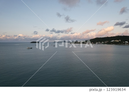 Boats peacefully anchored in a beautiful bay during sunset near a coastal town Boats peacefully anchored in a beautiful bay during sunset near a coastal town 123919634