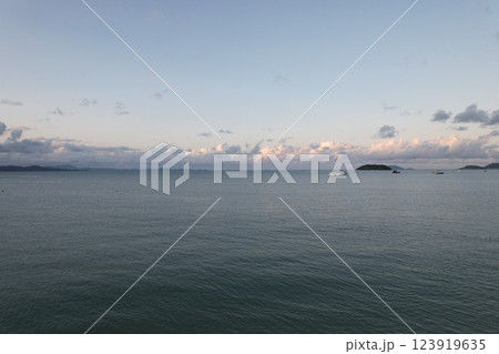 Tranquil coastal landscape at dusk with boats in the distance Tranquil coastal landscape at dusk with boats in the distance 123919635
