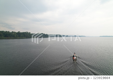 Boat traversing a calm river in the Amazon rainforest at dusk Boat traversing a calm river in the Amazon rainforest at dusk 123919664