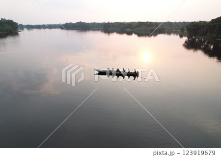 Rowing on a serene river with six people under the setting sun Rowing on a serene river with six people under the setting sun 123919679