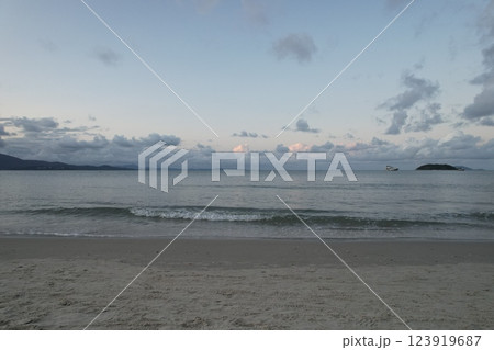 Serene beach view with gentle waves and clouds at sunset Serene beach view with gentle waves and clouds at sunset 123919687