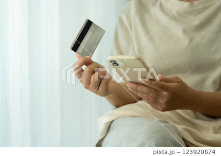 Close up of woman using a smartphone and credit card for an online purchase 123920874