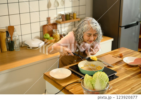 Happy senior woman preparing a simple breakfast in a modern kitchen 123920877