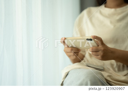 Excited woman playing a game on her smartphone in bright living room 123920907
