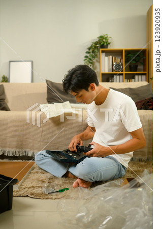 Young man selecting a tool from a drill set preparing to assemble furniture 123920935