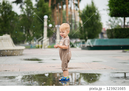 Toddler Playing in a Rain Puddle Outdoors Toddler Playing in a Rain Puddle Outdoors 123921085