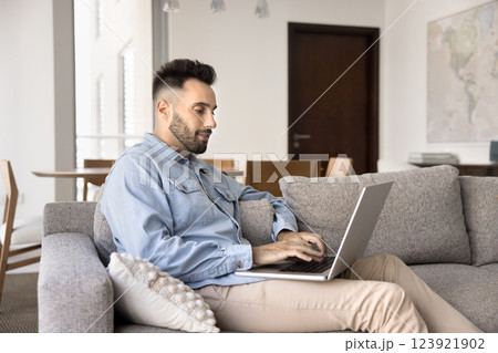 Handsome Spaniard man resting at home using his modern laptop 123921902