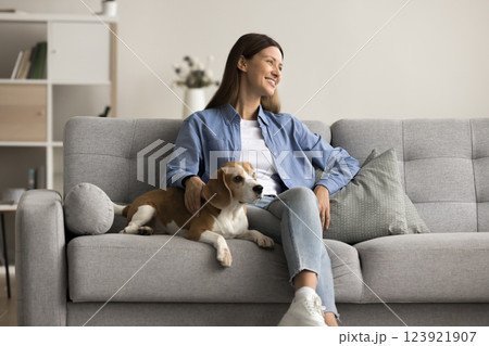 Dreamy wellbeing woman resting with lovely beagle dog at home Dreamy wellbeing woman resting with lovely beagle dog at home 123921907