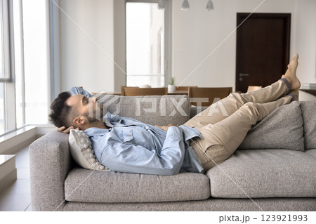 Hispanic man sleeping lying on comfortable sofa in living room Hispanic man sleeping lying on comfortable sofa in living room 123921993