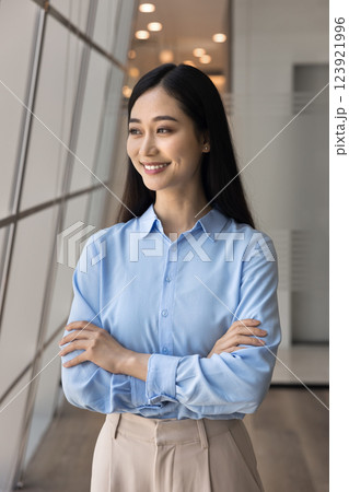 Young Asian businesswoman posing in modern office with arms crossed Young Asian businesswoman posing in modern office with arms crossed 123921996
