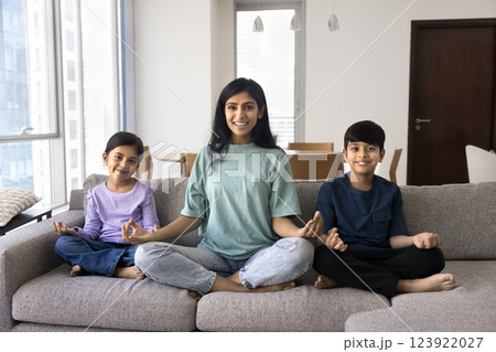 Portrait of Indian wellbeing family doing yoga at home 123922027