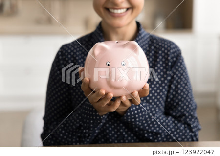 Closeup cropped portrait happy young woman hold piggybank in hands Closeup cropped portrait happy young woman hold piggybank in hands 123922047