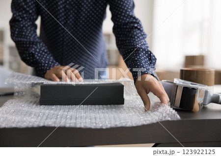 Saleswoman pack box with client order into bubble tape Saleswoman pack box with client order into bubble tape 123922125