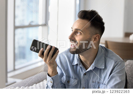 Man holding smartphone lead talk using speakerphone 123922163