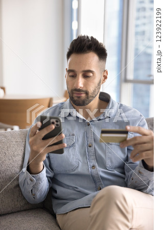 Man buying gifts, booking services using smartphone and debit card Man buying gifts, booking services using smartphone and debit card 123922199