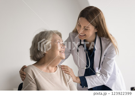 Professional medic worker hug shoulders of smiling older age female 123922399