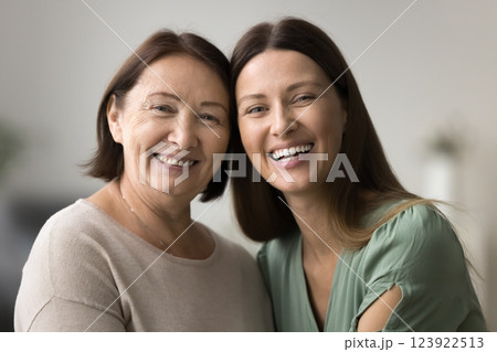 Two beautiful older and younger women posing for camera Two beautiful older and younger women posing for camera 123922513