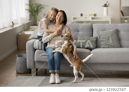 Girl cuddling older loving granny posing for camera with dog Girl cuddling older loving granny posing for camera with dog 123922597