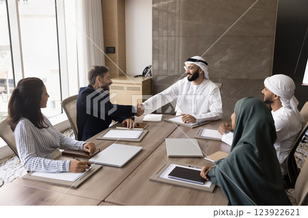 Arabian and European businessmen shaking hands start meeting in boardroom 123922621