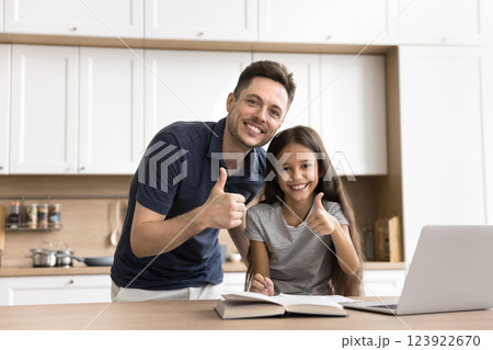 Junior daughter young father show thumbs up after studying lessons Junior daughter young father show thumbs up after studying lessons 123922670