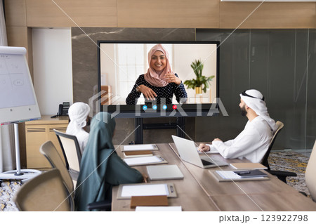 Arabian businesspeople taking part in virtual meeting in conference room 123922798