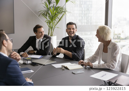 Joyful corporate business team laughing having fun at conference table Joyful corporate business team laughing having fun at conference table 123922815
