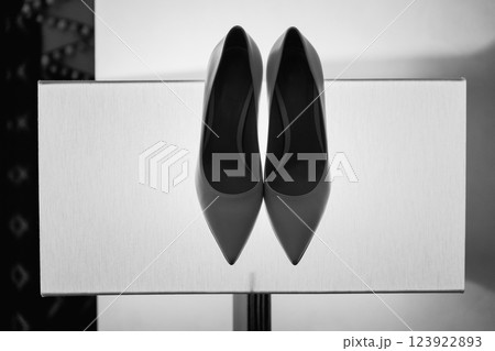 Beige high-heeled shoes with a pointed end in the studio on a yellow glowing background. The concept of selling or wedding shoes. Perfect for the fashion enthusiasts and brides-to-be seeking elegance. Beige high-heeled shoes with a pointed end in the studio on a yellow glowing background. The concept of selling or wedding shoes. Perfect for the fashion enthusiasts and brides-to-be seeking elegance. 123922893