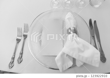 A clean plate, napkin and cutlery on a white table waiting for a delicious treat is the perfect backdrop for a joyful, memorable festive the wedding gala lunch dinner Devices made of expensive silver 123922910