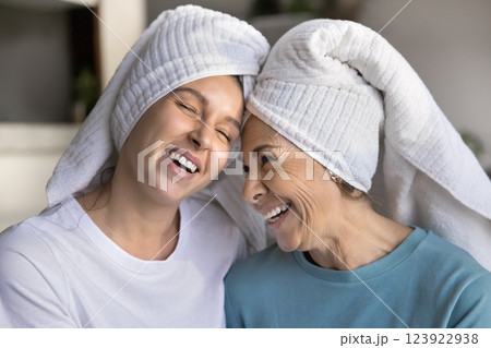 Older woman and daughter wrapped in towels sitting on sofa 123922938