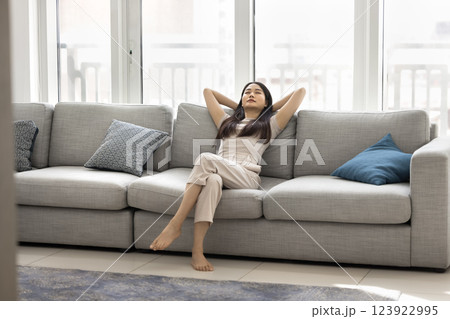 Silent Chinese woman reclining comfortably on sofa 123922995