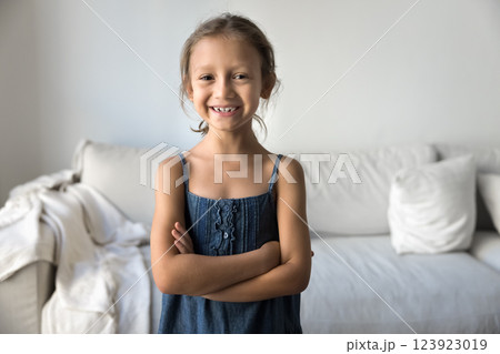Little girl standing in living room with her arms-crossed Little girl standing in living room with her arms-crossed 123923019