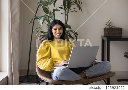 Woman spend time on internet seated in armchair with laptop 123923021