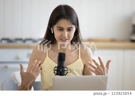 Young woman in earbuds record podcast using professional microphone notebook 123923054