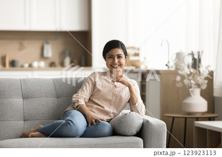Beautiful smiling young woman rest on sofa look at camera Beautiful smiling young woman rest on sofa look at camera 123923113