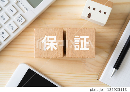 保証と書かれたブロック、電卓、家のおもちゃ 保証と書かれたブロック、電卓、家のおもちゃ 123923118