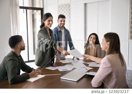 Female boss handing over document to client or colleague Female boss handing over document to client or colleague 123923217