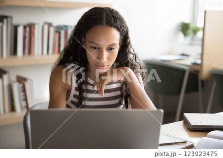 Student engaged in e-learning seated table with modern laptop Student engaged in e-learning seated table with modern laptop 123923475