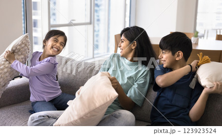 Mom and kids having fun, holding cushions beating each other 123923524