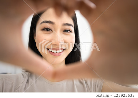Close up face of woman framing camera with hands 123923635
