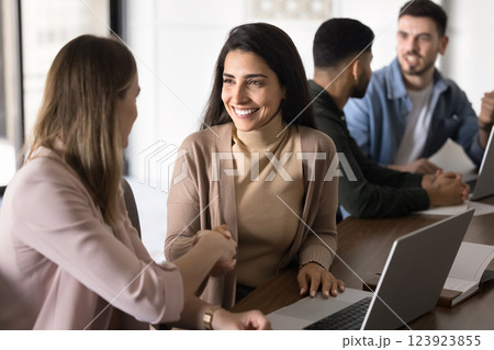Businesswomen shake hands, celebrating completion of successful project or goal Businesswomen shake hands, celebrating completion of successful project or goal 123923855
