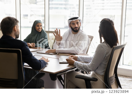 Multicultural business partners talking gathered in conference room 123923894