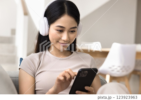 Close up of young Asian woman wear headphones using smartphone 123923963