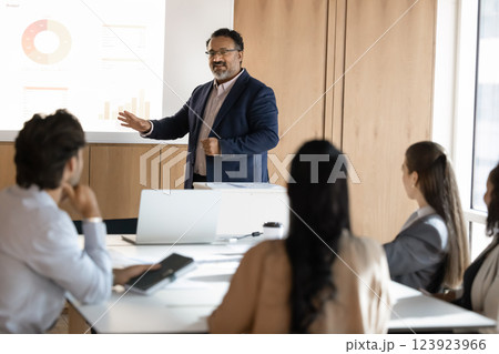Older Indian team leader man presenting marketing data to colleagues 123923966